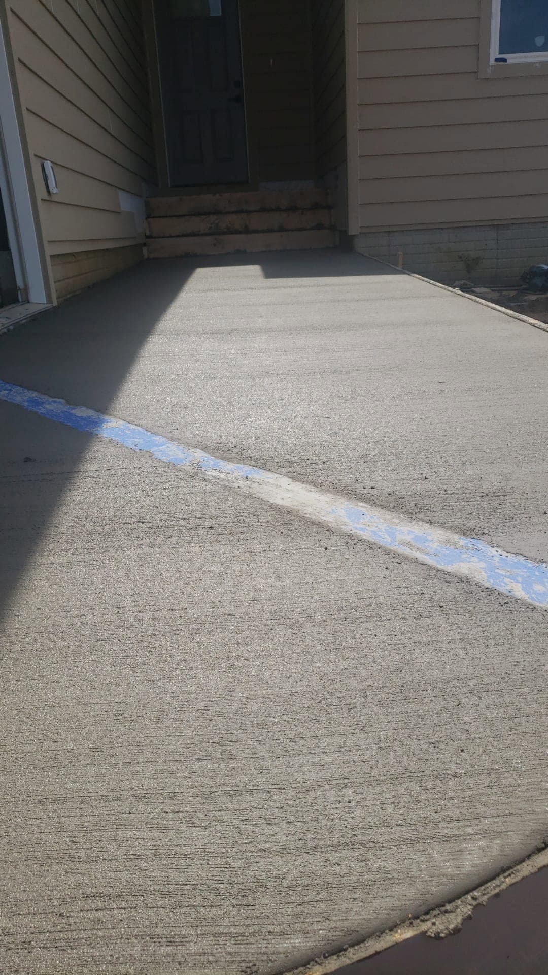 A close look at the ridged broom finish on a fresh concrete surface with a chalk control line