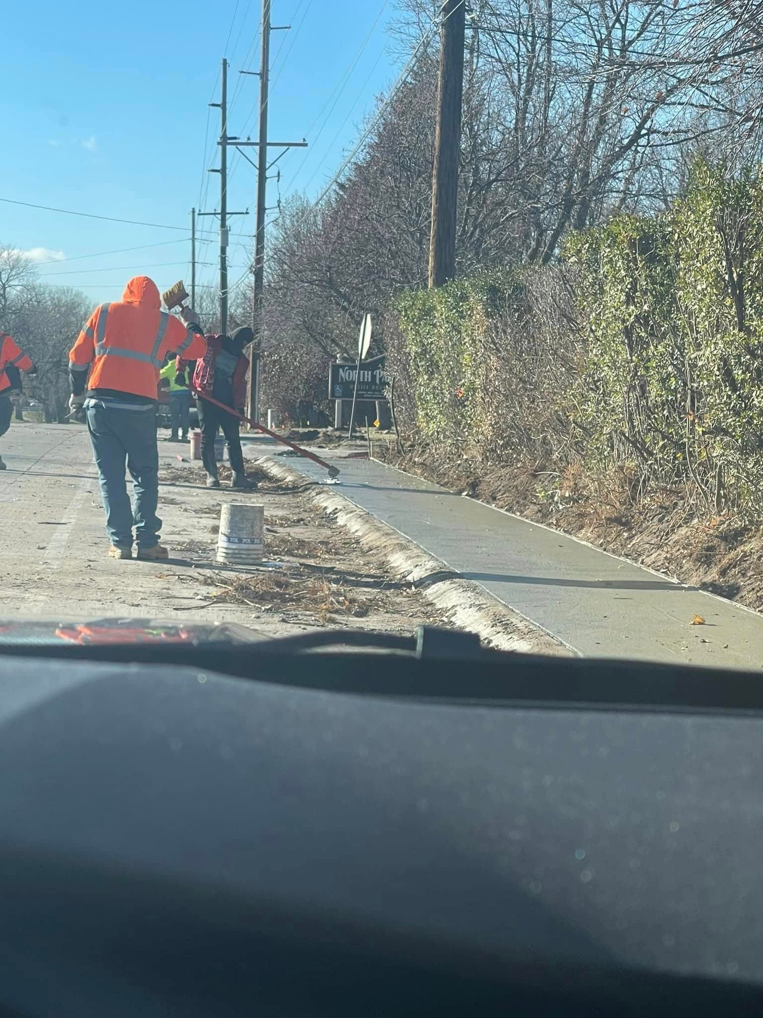 An EPJ crew finishing a public sidewalk along a Sioux Falls street
